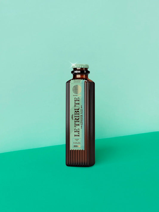 LE Tribute Ginger Ale 200ml bottle, crafted with natural ginger aroma and the signature ribbed glass design on a turquoise background