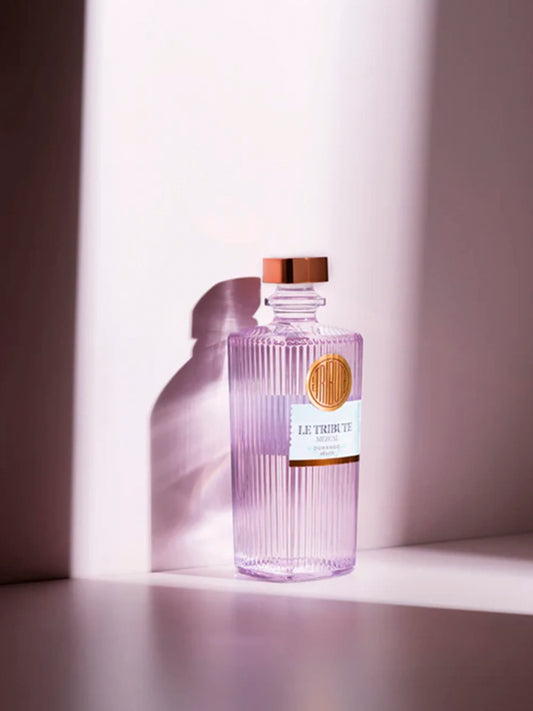 LE Tribute Mezcal: Minimalist shot of the lilac-tinted glass bottle with signature ribbed texture and branding