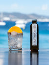 LE Tribute Tonic Water Zero Sugar used to make a refreshing gin cocktail with orange and ice, served outdoors