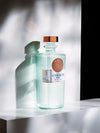 LE Tribute Gin bottle on a white surface, illuminated to create artistic shadows, highlighting its clean design