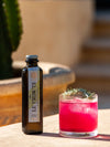 Creating a Mediterranean-inspired cocktail with LE Tribute Olive Lemonade, perfect for outdoor enjoyment