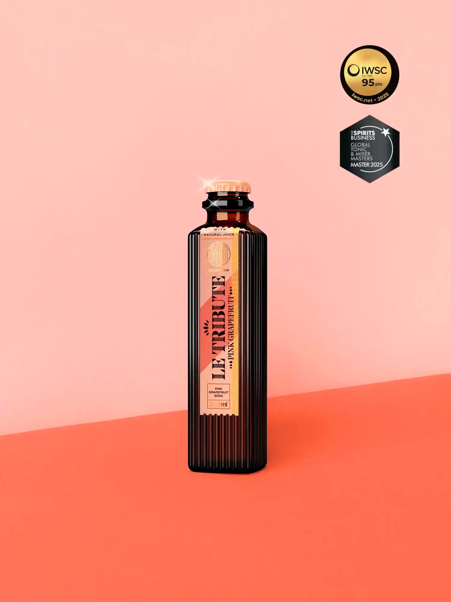 LE Tribute Pink Grapefruit Soda 200ml bottle, crafted with natural pink grapefruit juice on a stylish coral background