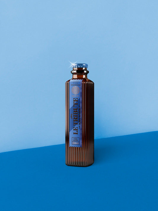 LE Tribute Soda Water 200ml bottle with ribbed glass design and natural quinine, on a blue background
